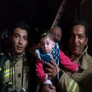 عکس/ نجات دختر بچه‌ ۸ ماهه از میان دود